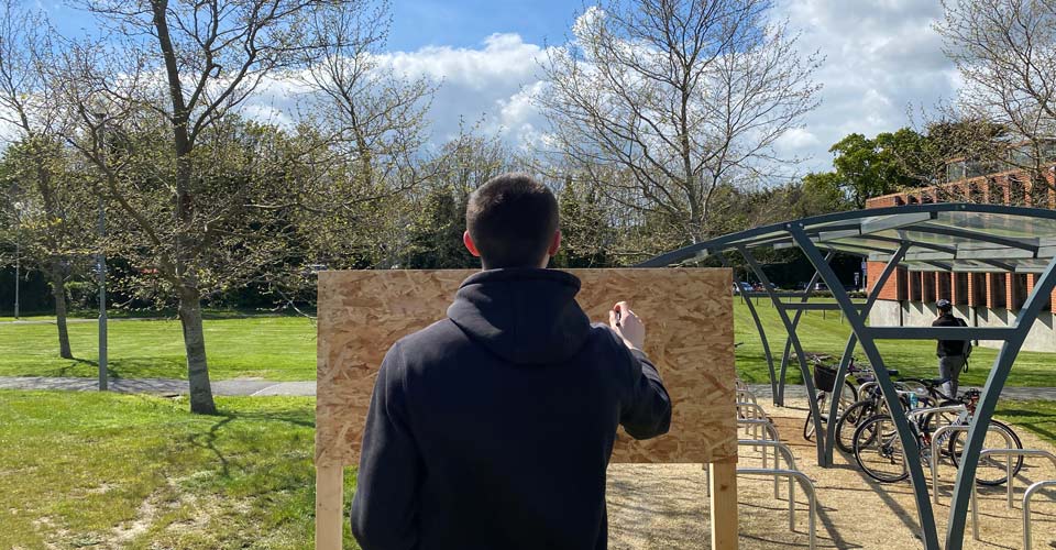 A landscape architecture student preparing a sign