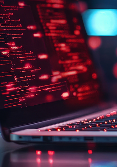 A close-up of a person's hands typing on a laptop keyboard, the screen is illuminated with red code. The image symbolizes ethical hacking, cybersecurity, digital security, data protection, and online